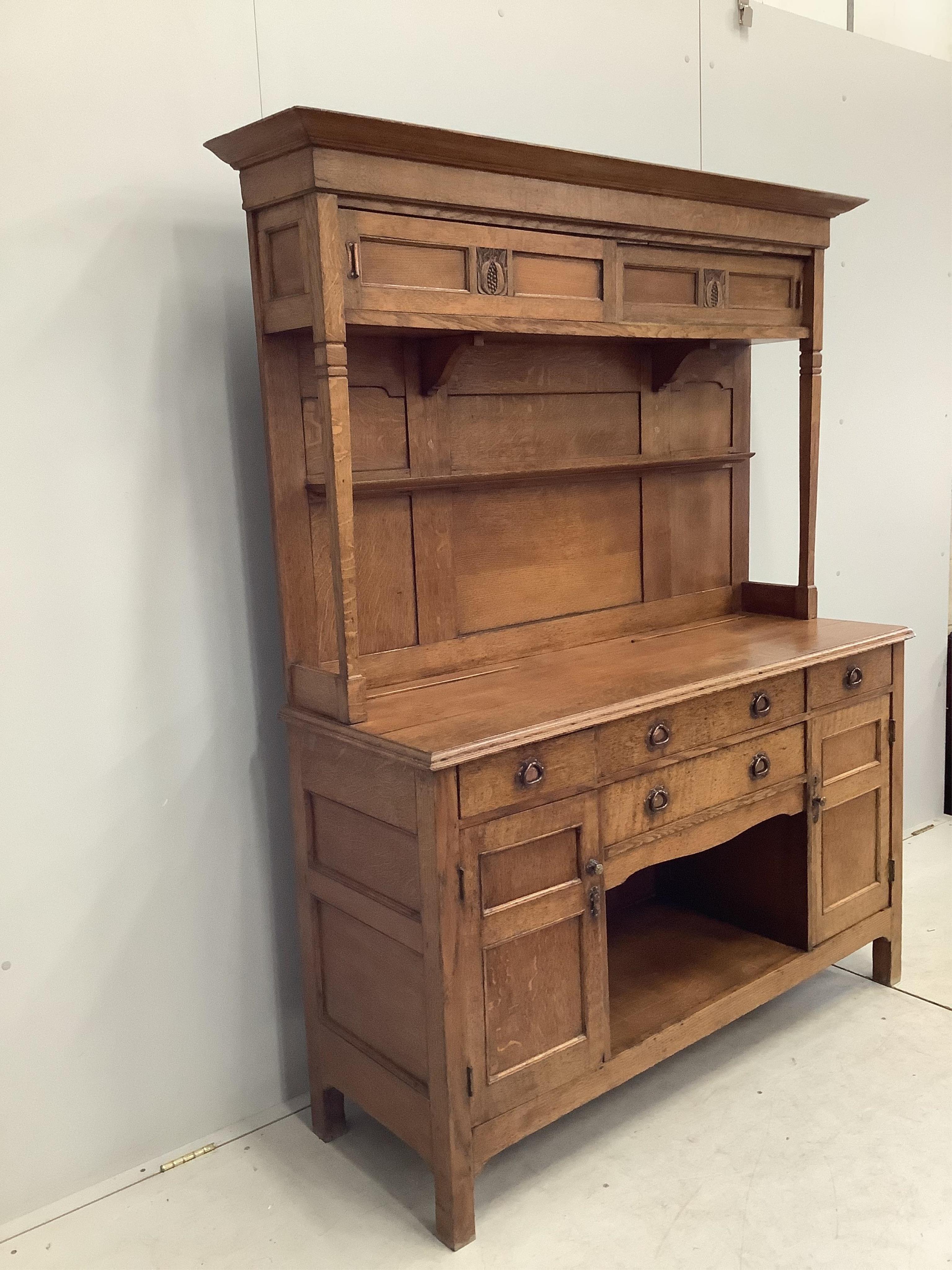 A small Arts & Crafts copper mounted oak dresser, width 140cm, depth 48cm, height 182cm. Condition - fair
